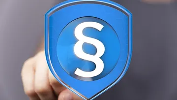 Ein Finger zeigt auf ein blaues Symbol mit Paragraphenzeichen.