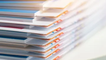 Viele Hefte liegen ordentlich aufeinander gestapelt.