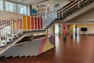 Flur mit Treppenaufgang mit bunten Geländer